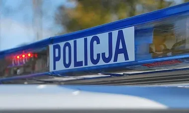 Fragment niebieskiego świetlnego dachu policyjnego radiowozu z napisem POLICJA.